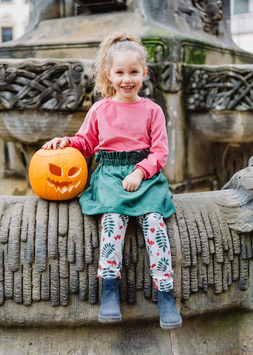 Kinder Outfit von internaht bestehend aus Nicki Pullover in Flamingo, grünem Cordrock und Leggings mit Beeren und Blättern alles aus Biobaumwolle